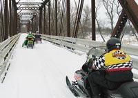 Snowmobiling over bridge